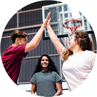 High-five tussen twee jongeren op een basket-ball veld